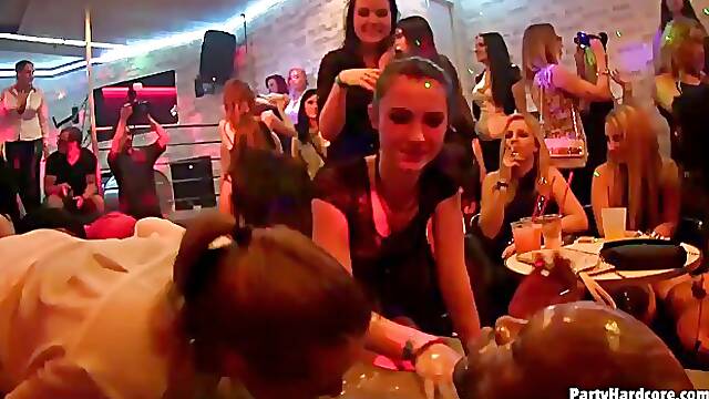Some naughty women at the party are using an opportunity to suck a dancer's hard cock